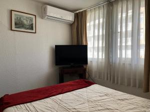 a bedroom with a bed and a flat screen tv at Chilhotel en Providencia in Santiago