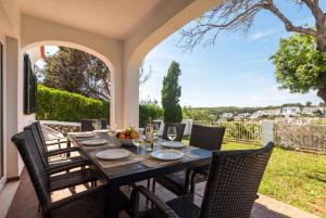 a table and chairs on a patio with a view at Villa Verano in Cala Galdana