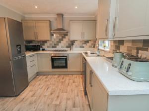 a kitchen with white cabinets and stainless steel appliances at 3 Railway Terrace in Bridlington