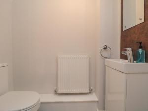 a white bathroom with a toilet and a sink at 3 Railway Terrace in Bridlington +14 photos