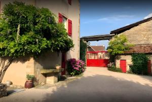 a building with a red door and a tree at Les Chambres du Clos De L'église in Senozan