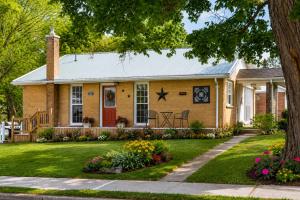 a yellow brick house with a red door at Downtown Picton Retreat - Near Sandbanks and Wineries in Picton