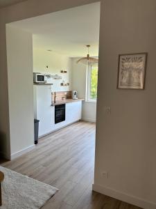 a kitchen with white walls and a wooden floor at La Bohème d'Opale in Boulogne-sur-Mer