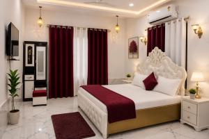 a bedroom with a large bed with red curtains at Green Valley Resort in Dūngarpur
