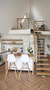 two white chairs in a kitchen with a staircase at Azad A-Frame in Şotrile +27 photos