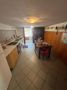 a kitchen with a table and a dining room at La Canàoula in Bobbio Pellice