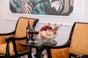 a table with two glasses of wine and a bowl of fruit at Doris Luxury Hotel in Hanoi