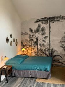 a bedroom with a blue bed and palm trees mural at Les Chambres du Clos De L'église in Senozan +58 photos