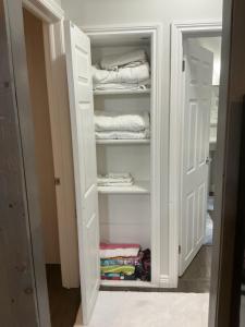 a closet with white doors and folded towels at Granary Guest House in Goderich
