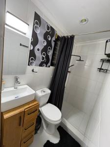 a bathroom with a toilet and a sink and a shower at Luxe cozy home in Dar es Salaam