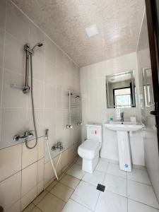 a bathroom with a toilet and a sink and a shower at Panoramic Mountains Hotel Guba in Qırızdǝhnǝ +49 photos