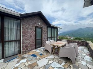 a patio with a table and chairs on a stone patio at Panoramic Mountains Hotel Guba in Qırızdǝhnǝ