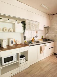 a kitchen with white cabinets and a microwave at Jian Stay Bora in Sin'gal