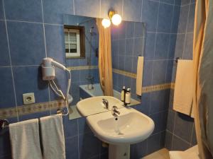 a bathroom with a sink and a mirror and towels at Hotel Reels - Residencial O TRINDADE in Águeda +14 photos