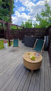 two chairs and a table on a wooden deck at Domki Natura Zator in Graboszyce