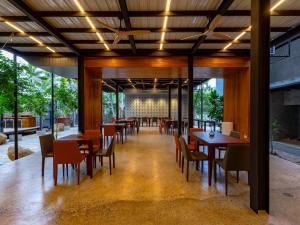a dining room with wooden tables and chairs at BlackRoots Unawatuna in Unawatuna