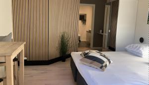 a bedroom with a large white bed and a desk at Lohals camping in Tranekær +2 photos