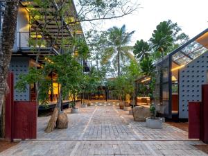 a courtyard with trees in front of a building at BlackRoots Unawatuna in Unawatuna