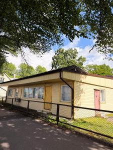 a yellow house with a fence in front of it at Sadama Hostel & Caravan Camping in Pärnu