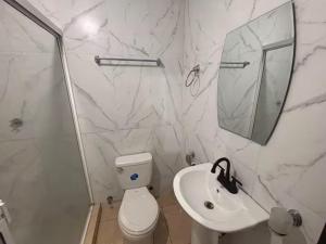 a bathroom with a sink and a toilet and a mirror at Chitre Villa by Otium in Monagrillo