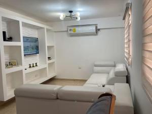 a living room with a couch and a tv at Chitre Villa by Otium in Monagrillo