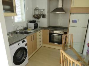a kitchen with a washing machine and a sink at Apartamento Tres Ce in Alcossebre