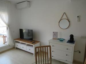 a room with a tv and a dresser and a mirror at Apartamento Tres Ce in Alcossebre