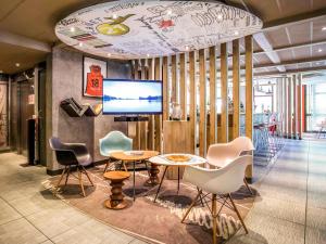 a room with chairs and a table and a tv at Ibis Bourges Centre, Hôtel Restaurant in Bourges
