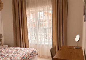a bedroom with a bed and a table and a window at The Old Corner House in Velingrad