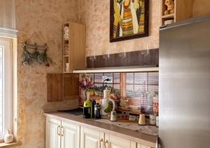 a kitchen with white cabinets and a stainless steel refrigerator at The Old Corner House in Velingrad