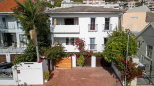 a white house with flowers in front of it at Villa Costa Rose in Cape Town +62 photos