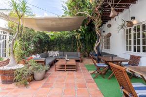 a patio with a couch and a table and chairs at Villa Costa Rose in Cape Town
