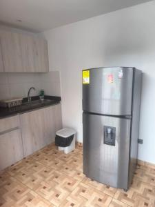 a kitchen with a stainless steel refrigerator in a room at apartamento vacacional red in Salento