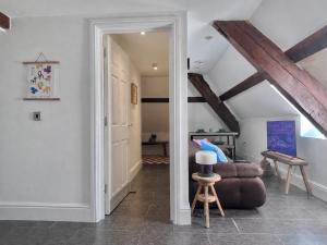 a living room with a couch and a chair at The Eaves - Pen Y Fan Views in Brecon