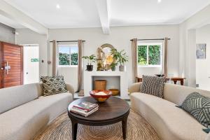a living room with two couches and a table at Villa Costa Rose in Cape Town
