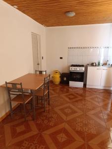 a kitchen with a table and chairs and a stove at Cabañas Wiñaypacha Putre in Putre +7 photos
