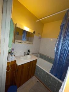 a bathroom with a sink and a tub and a shower at Appartement Mona Lisa in Ris-Orangis