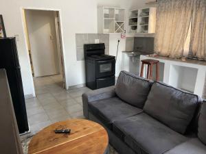 a living room with a leather couch and a table at Kokoma Apartment in Katima Mulilo in Katima Mulilo