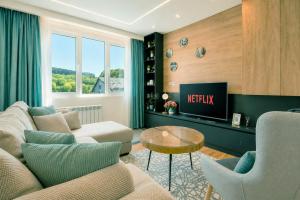 a living room with a couch and a tv at Modern Harmony in Kolašin