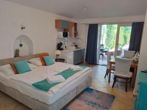 a bedroom with a large bed and a kitchen at Csopak Mariann Apartman in Csopak