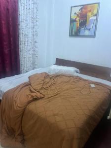 an unmade bed in a bedroom with a picture on the wall at Chepchephm in Makindi