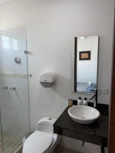 a bathroom with a sink and a toilet and a mirror at Hotel LHM in Montería +31 photos