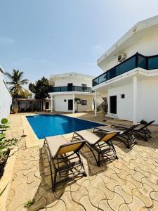 a house with a swimming pool and some chairs at Izuba chambres avec vue sur piscine in Ngaparou