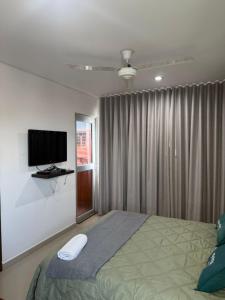 a bedroom with a bed with a television on the wall at Hotel LHM in Montería