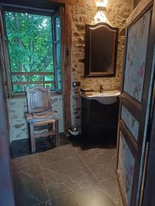 a bathroom with a chair and a sink at La petite Salamandre bleue in La Croisille-sur-Briance +3 photos