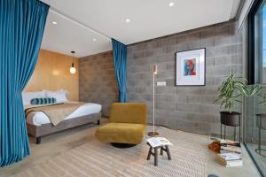 a bedroom with a bed and a chair at The 21 by Homie in Ribeira Brava
