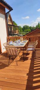 a patio with a table and chairs on a deck at MAKS HOUSE KASZUBY Balia Lake and Forest Retreat in Przewóz +11 photos