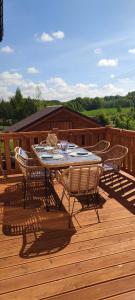 a table and chairs on a wooden deck at MAKS HOUSE KASZUBY Balia Lake and Forest Retreat in Przewóz