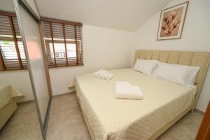 a bedroom with a bed with two towels on it at Green Oasis Residence in Radanovići