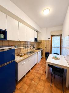 a large kitchen with white cabinets and a table at Rome Home Cinecittà in Rome
